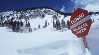 An avaance danger sign in deep snow at a ski resort