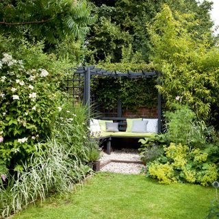 garden grass area with black painted pergola seating area