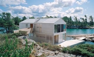 House built on water with a wooden walkway to the land