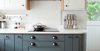 white and blue kitchen with induction hob and clear white marble worktops