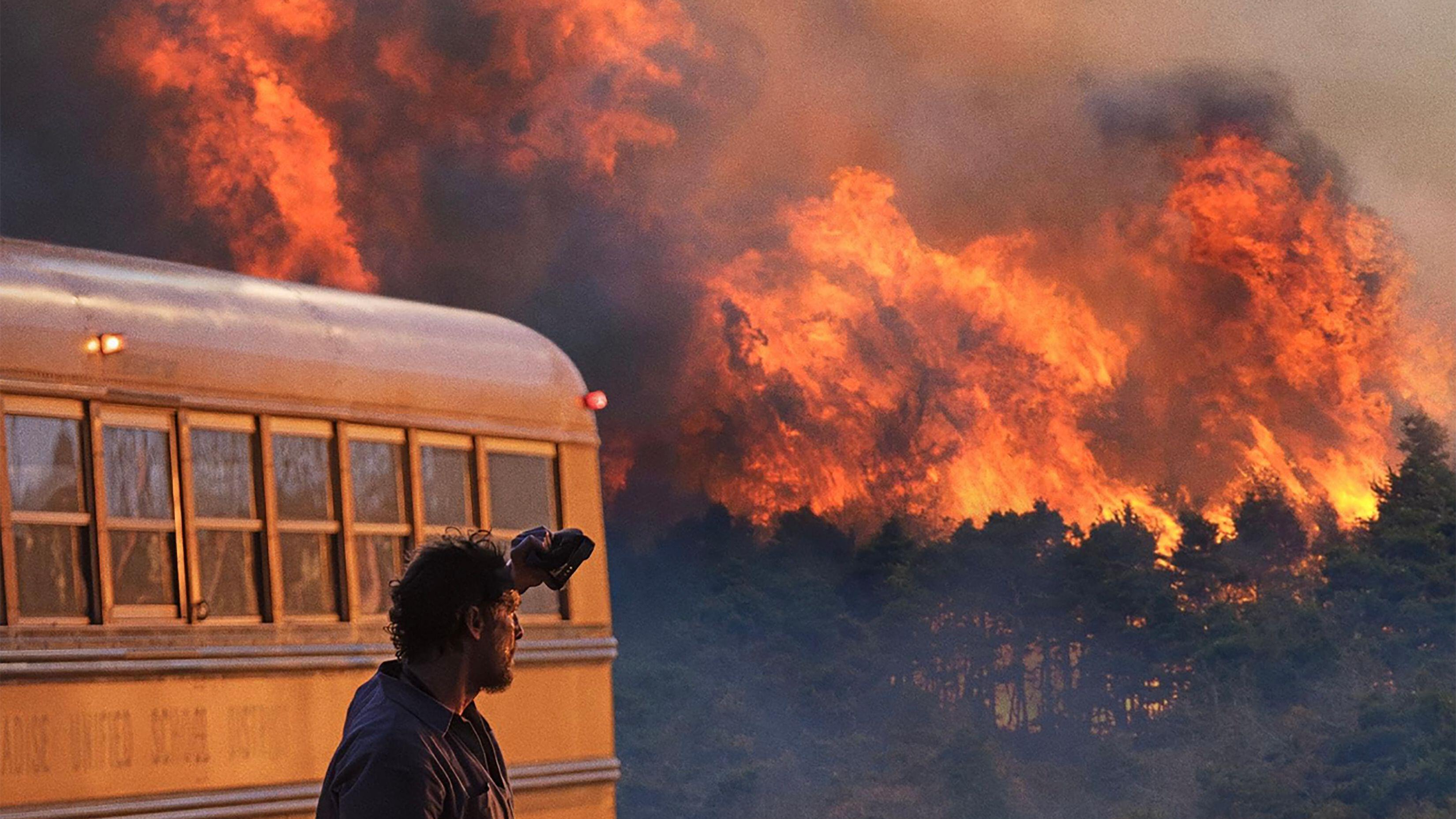 Kevin (Matthew McConaughey) watches the flames from afar in a scene from Apple TV Plus&#039;s &amp;quot;The Lost Bus&amp;quot;