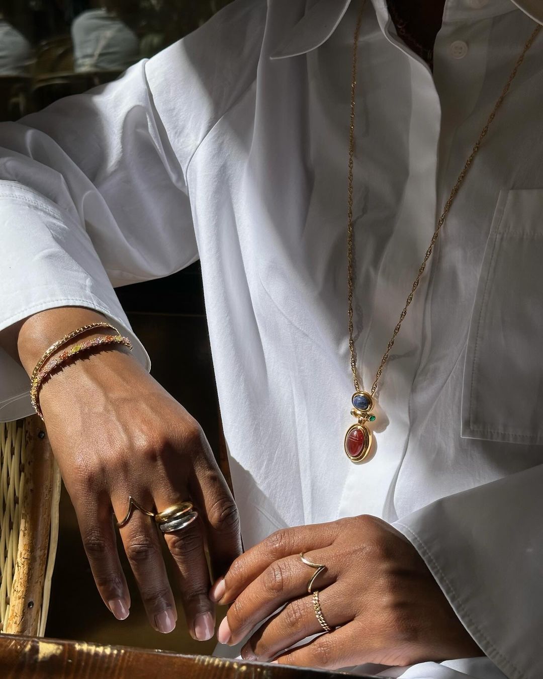 @frannfyne wearing bracelets, rings and necklace with white shirt