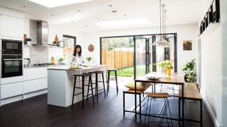white light-filled kitchen extension with industrial style seating and dining table