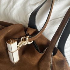 Chanel Coco Mademoiselle purse chain attached to a brown suede handbag