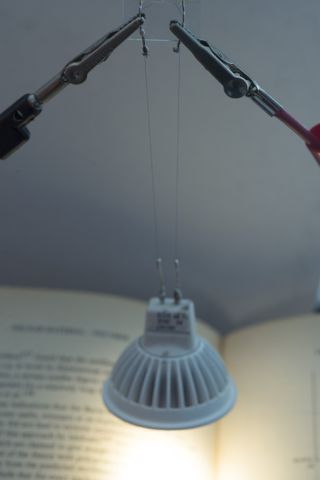 This light bulb is powered and held in place by two thin strands of carbon nanotube fibers that look and feel like textile thread. The nanotube fibers conduct heat and electricity as well as metal wires but are stronger and more flexible.