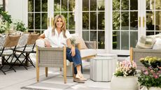 designer shea mcgee sat on a patio sofa in a garden styled with her studio mcgee for target spring 2025 collection