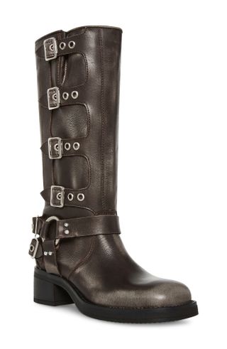 a tall pair of leather boots has four buckles going down the sides