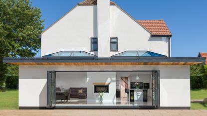 An external shot of a large detached house with two roof lanterns and bi-fold doors