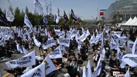 Members of the Samsung Electronics labour union hold flags as they stage a mass rally demanding the removal of a cap on performance bonuses
