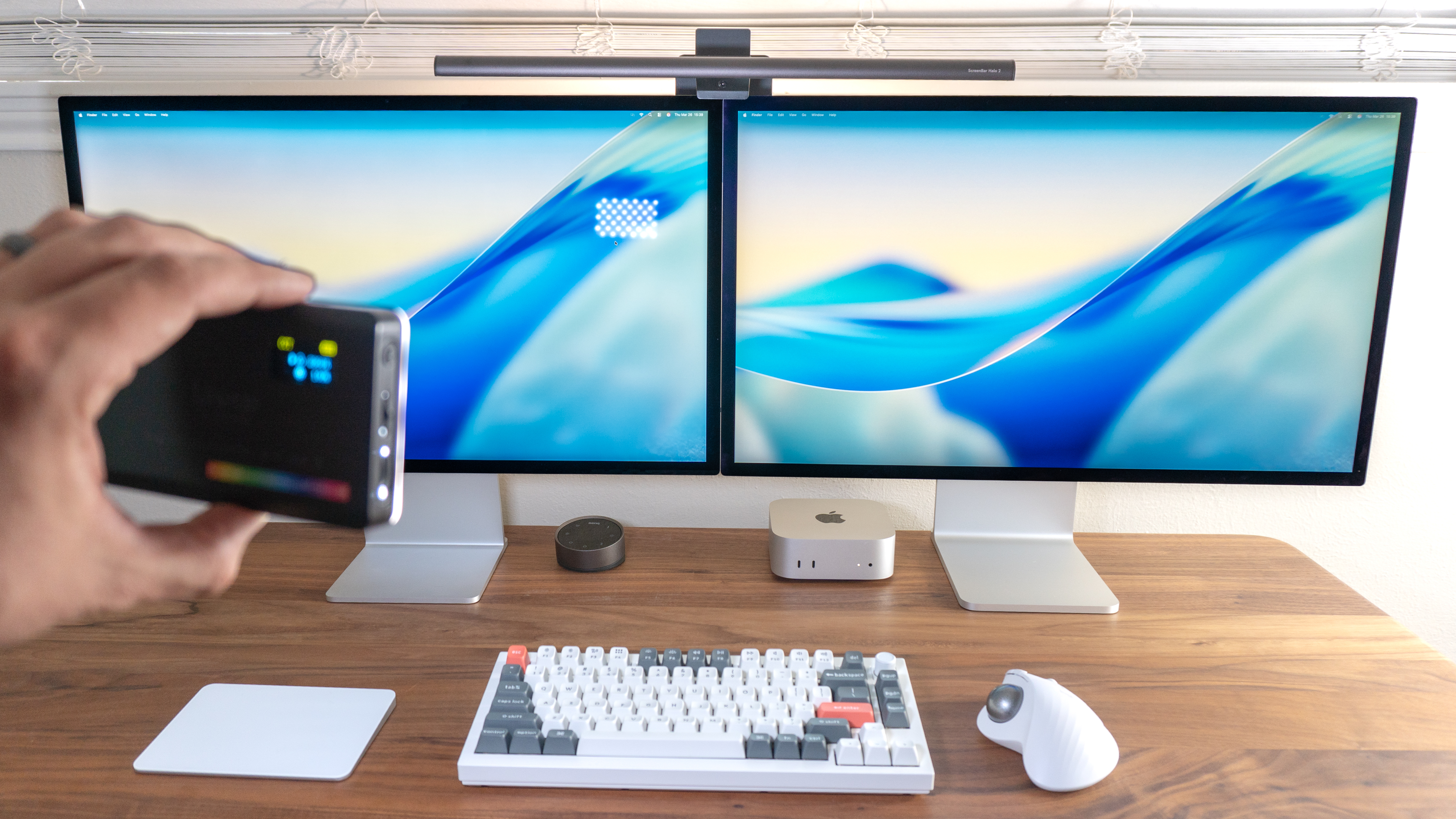 A person shining an LED video light at an Apple Studio Display with the standard glass option to show the difference between it and the nano texture glass one