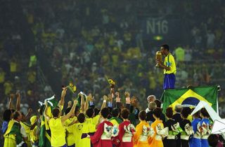 Cafu stands on the podium with the World Cup trophy after Brazil's win over Germany in the 2002 World Cup final in Yokohama.