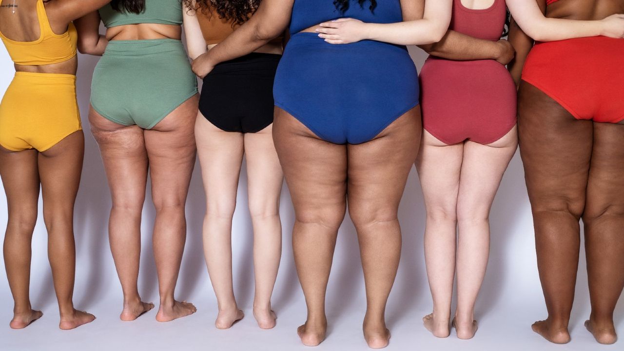 Diverse group of women stand together in brightly coloured lingerie.