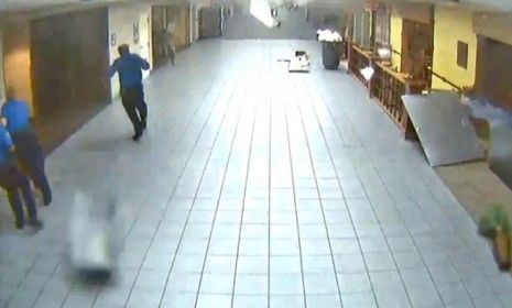 Security guards take cover in the St. Louis airport Friday, as a tornado wreaks havoc on one of the terminals, causing chunks of the ceiling to fall.