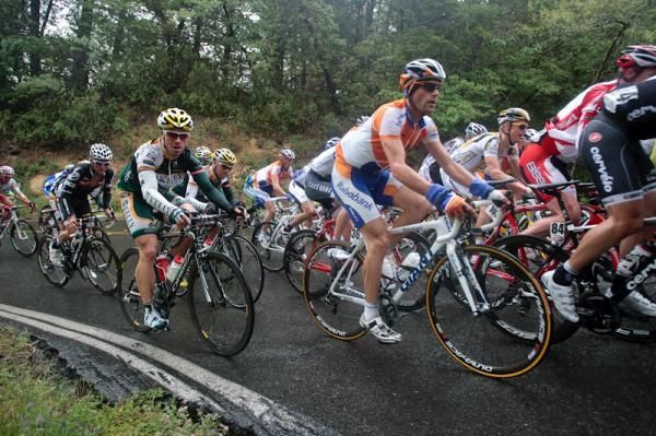 The peloton rounds a corner in the tricky conditions.