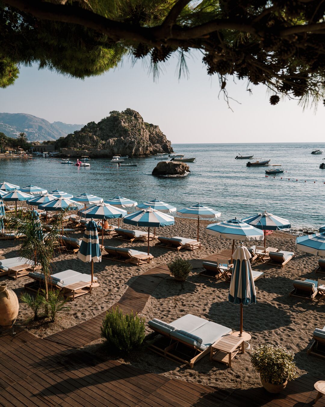 Sun loungers and blue and white parasols on a shingle beach