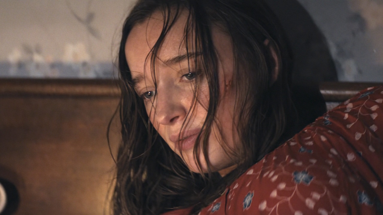 Lisa laying in bed pregnant with her hair in her face in Netflix's Thrash