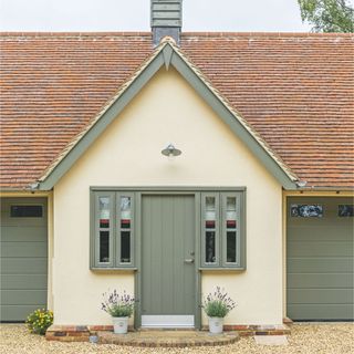 Solid front door of new build oak frame home, with windows either side to bring in light