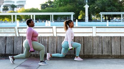 Two women performing dumbbell lunges