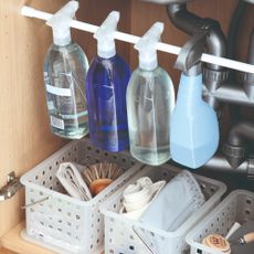 An under-sink cupboard with cleaning products and supplies