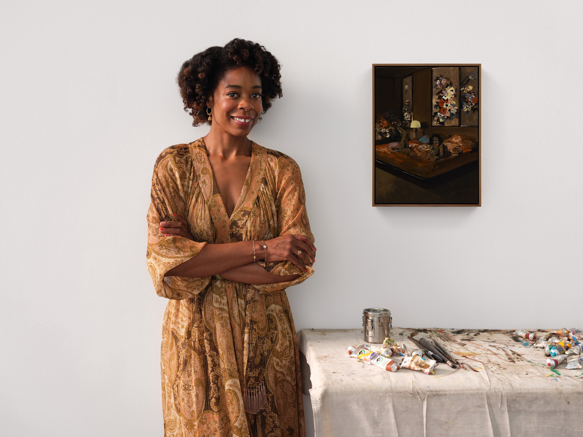 American artist Danielle Mckinney in her studio beside a painting and art materials