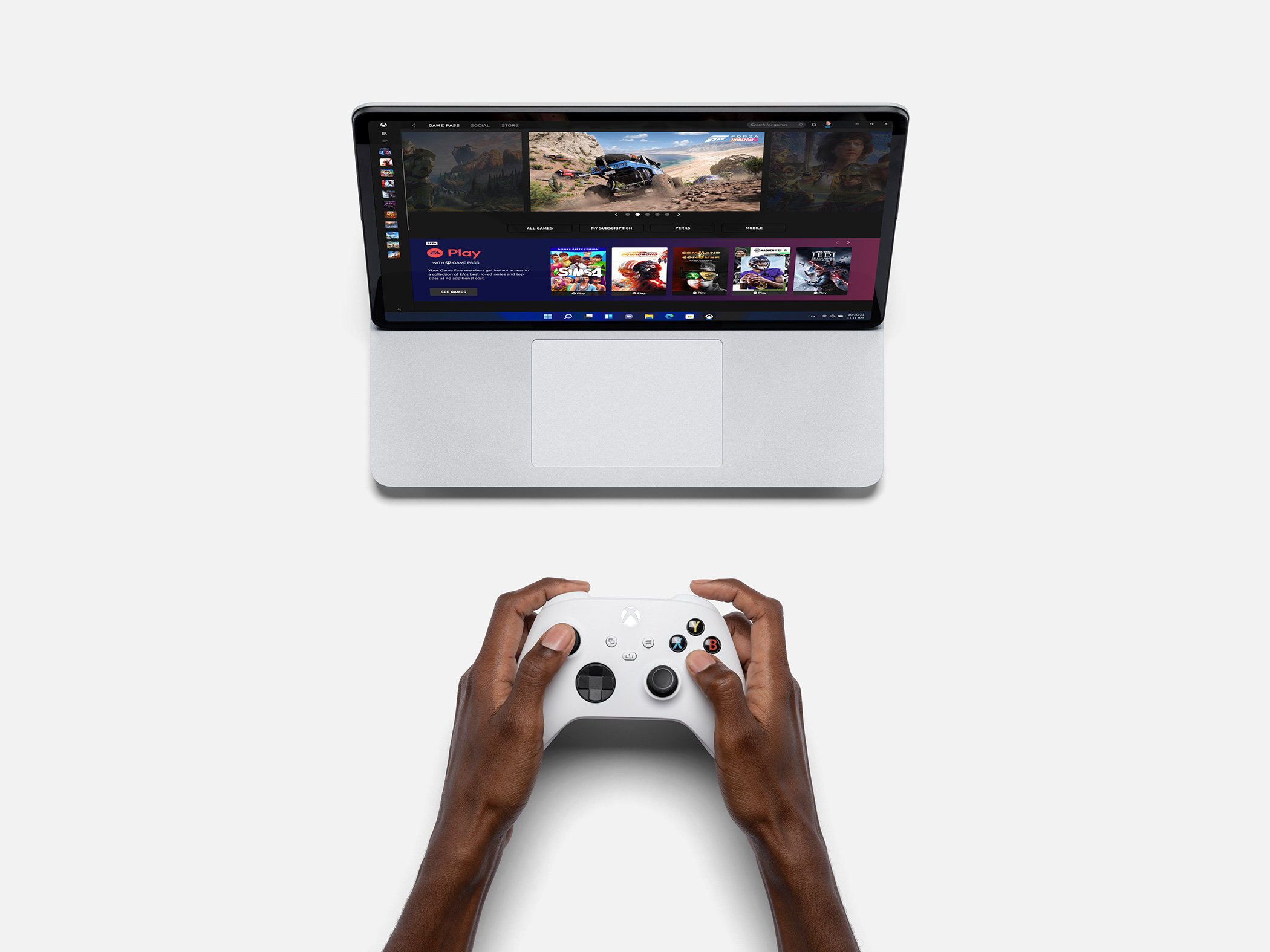 Microsoft Surface Laptop Studio with the Xbox app open with someone playing an X-Box controller in front of it
