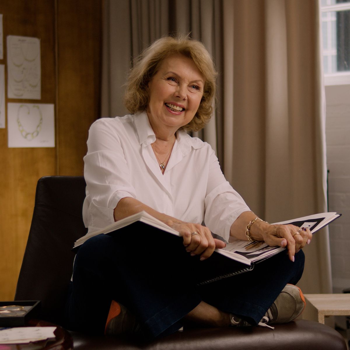 jewellery designer dinny hall sits on her desk