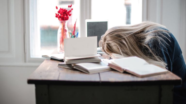 Sleep deprivation effects: Woman with head slumped on desk
