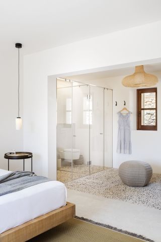 A bathroom with a WC hidden behind the glass, in a master bedroom