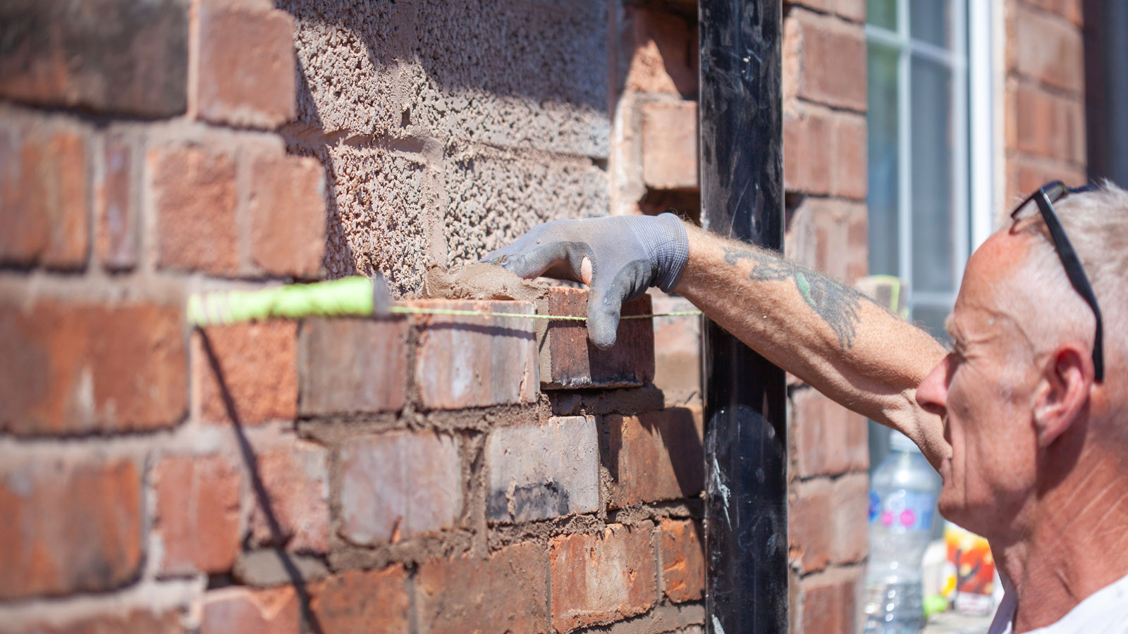 man bricking up a window