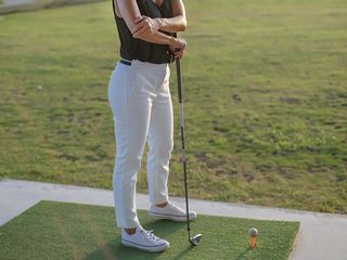 Lady suffering with golfer's elbow on the driving range