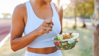 woman eating a healthy salad after workout