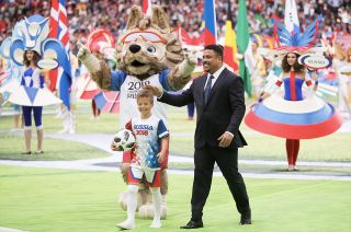 A young boy holds the space station-flown Adidas Telstar 18 soccer ball alongside Brazilian striker Ronaldo and mascot Zabivaka at the 2018 FIFA World Cup opening ceremony in Moscow on June 14, 2018.