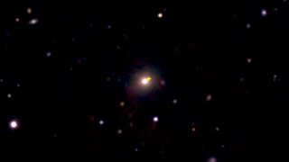 Image from the European Southern Observatory New Technology Telescope showing the distant red galaxy (center) where the explosion occurred. The explosion site is marked by the yellow cross.