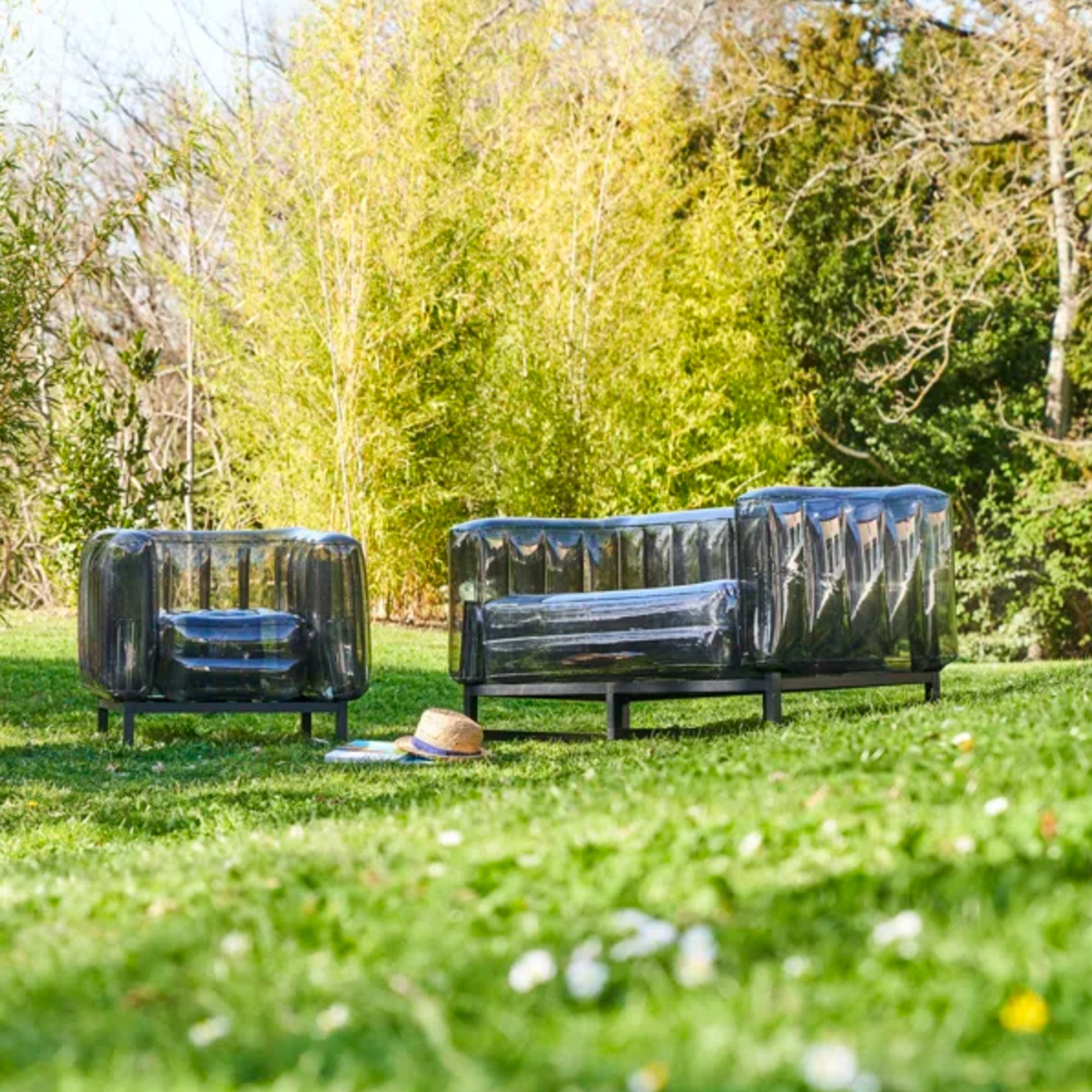 Mojow Yomi 151cm Wide Outdoor Patio Sofa with Cushions in black in the garden with a matching armchair