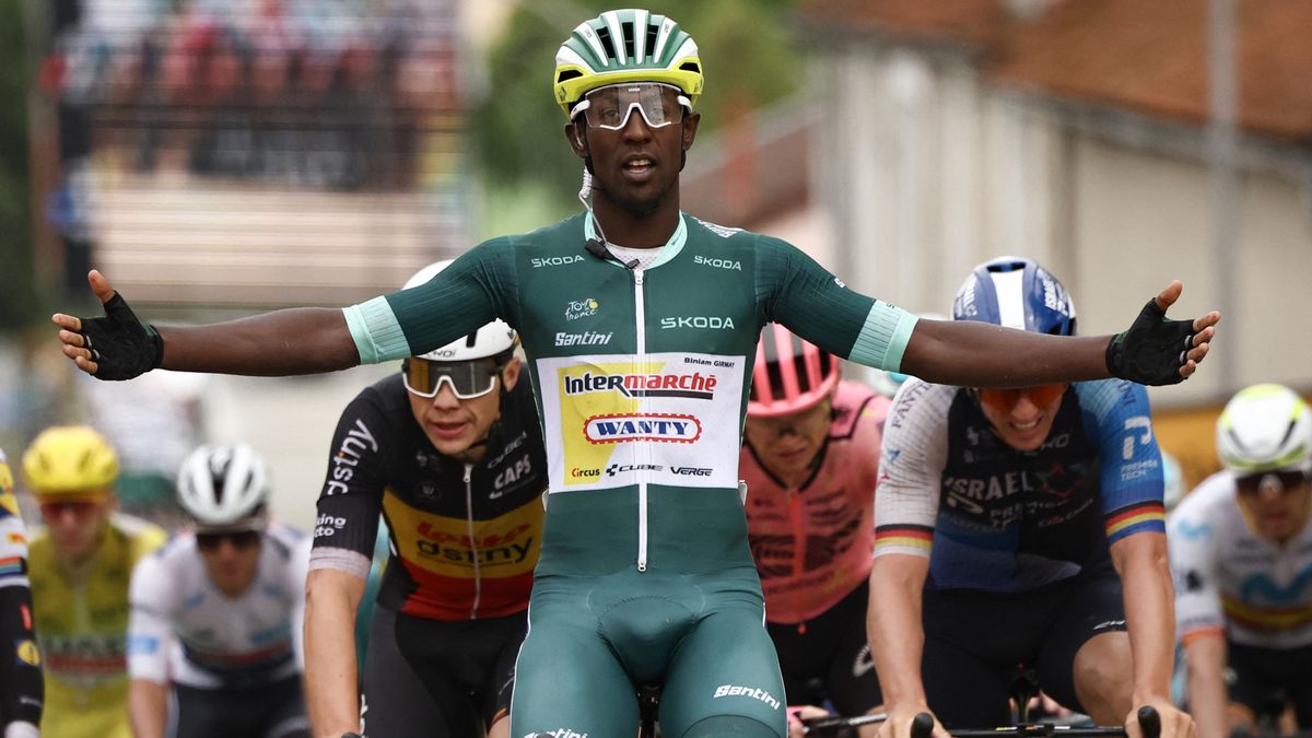 Biniam Girmay crosses the line for a stage win at the Tour de France 2024 wearing the sprinters&#039; green jersey.