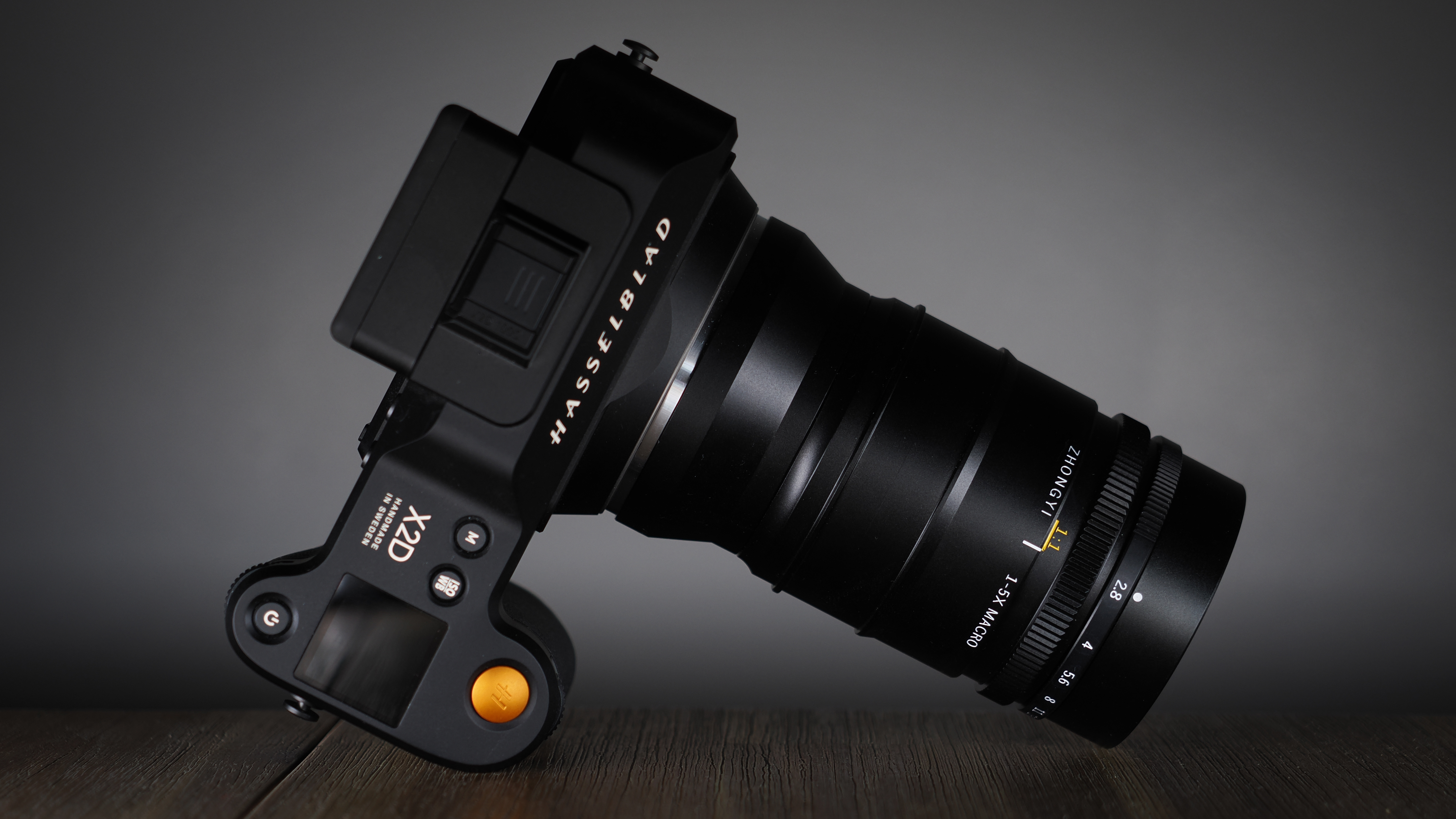 Mitakon 55mm f/2.8 1-5x Macro mounted to. a Hasselblad X2D, on a wooden surface