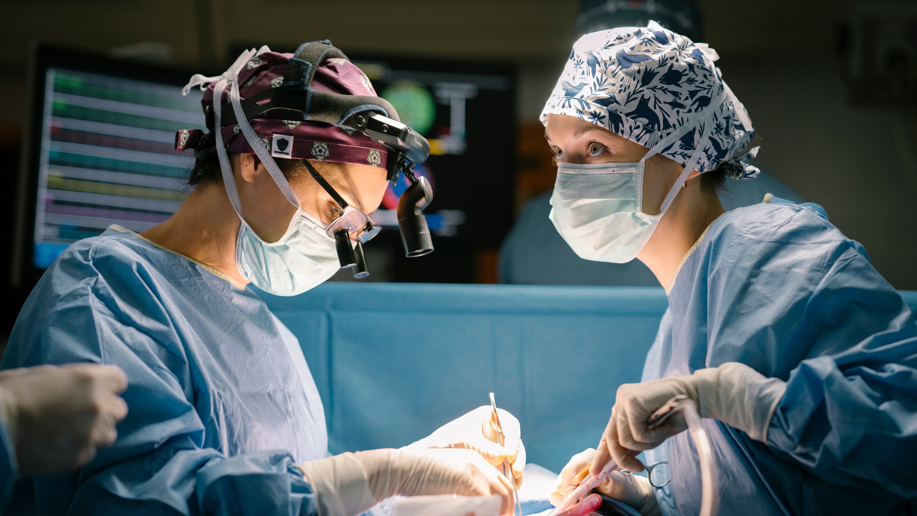 Annabel Scholey as Charlotte and Aggy K Adams as Mia in scrubs and mask during an operation in The Couple Next Door Season 2