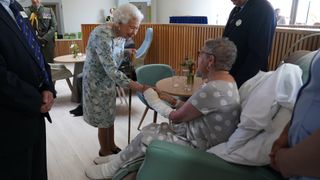 Queen Elizabeth II meets patient Pat White during a visit to officially open the new building at Thames Hospice
