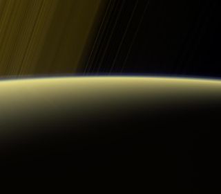 A false-color view from the Cassini spacecraft shows Saturn's rings arcing past the planet's horizon. The image was taken using the spacecraft's red, green and ultraviolet spectral filters on July 16, 2017, at 777,000 miles (1.25 million kilometers) from Saturn. Each pixel spans about 4 miles (7 km).