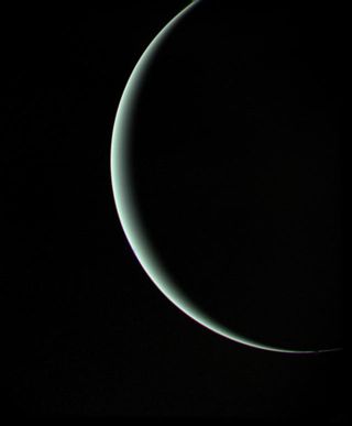 Voyager 2 departs a crescent Uranus on January 25, 1986, here seen from a range of 600,000 miles.
