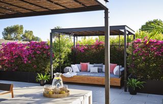 backyard with flower covered trellis and day bed by Kathy Taslitz