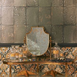 A bathroom decorated with antique tile wallpaper behind a dressing table and mirror