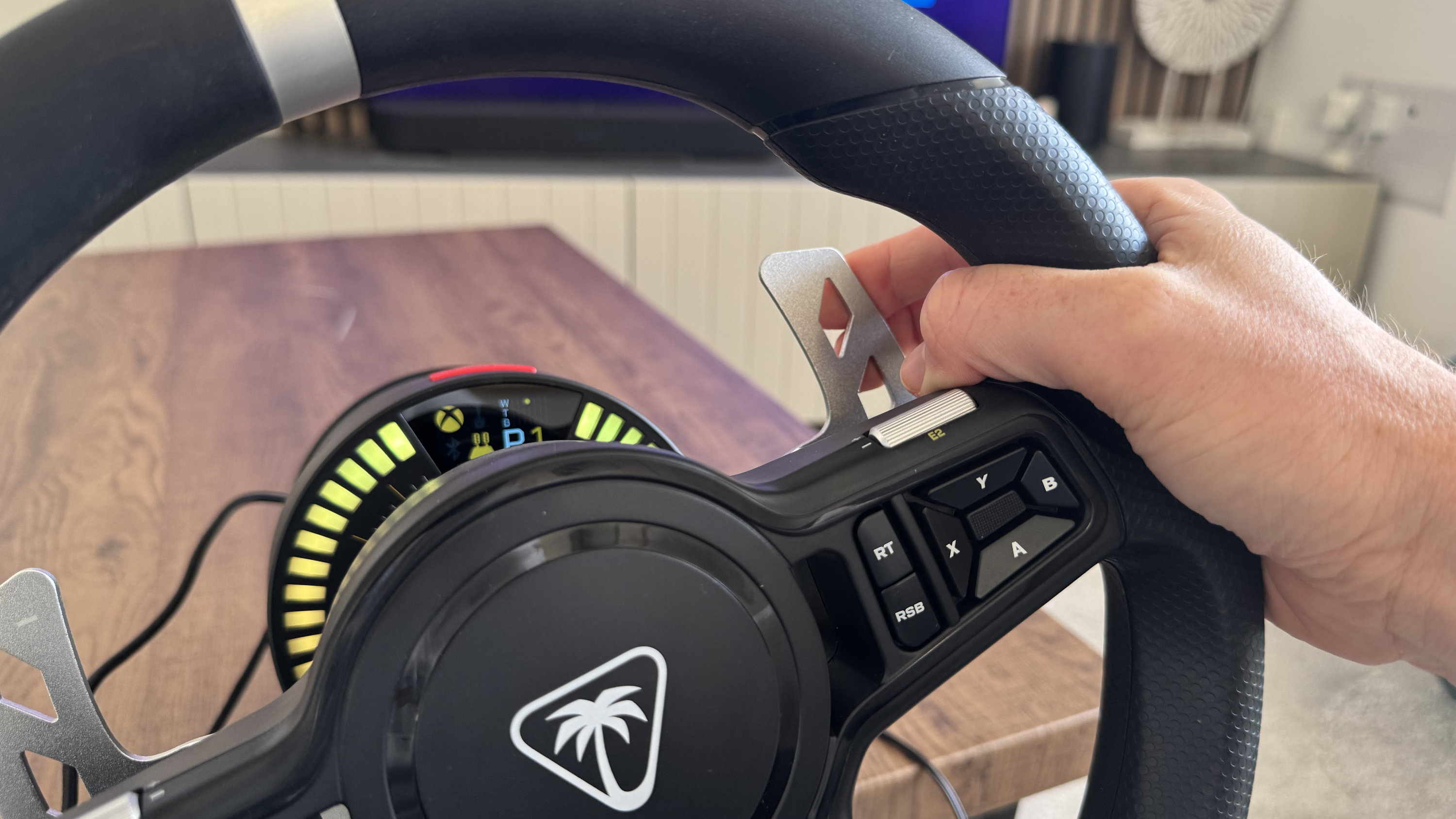 A reviewer using the gear shifting paddle on the back of the Turtle Beach VelocityOne Race KD3 round wheel