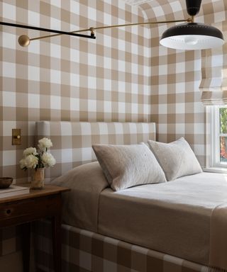 neutral beige gingham pattern drenched bedroom with matching wallpaper, window dressing and upholstered bed