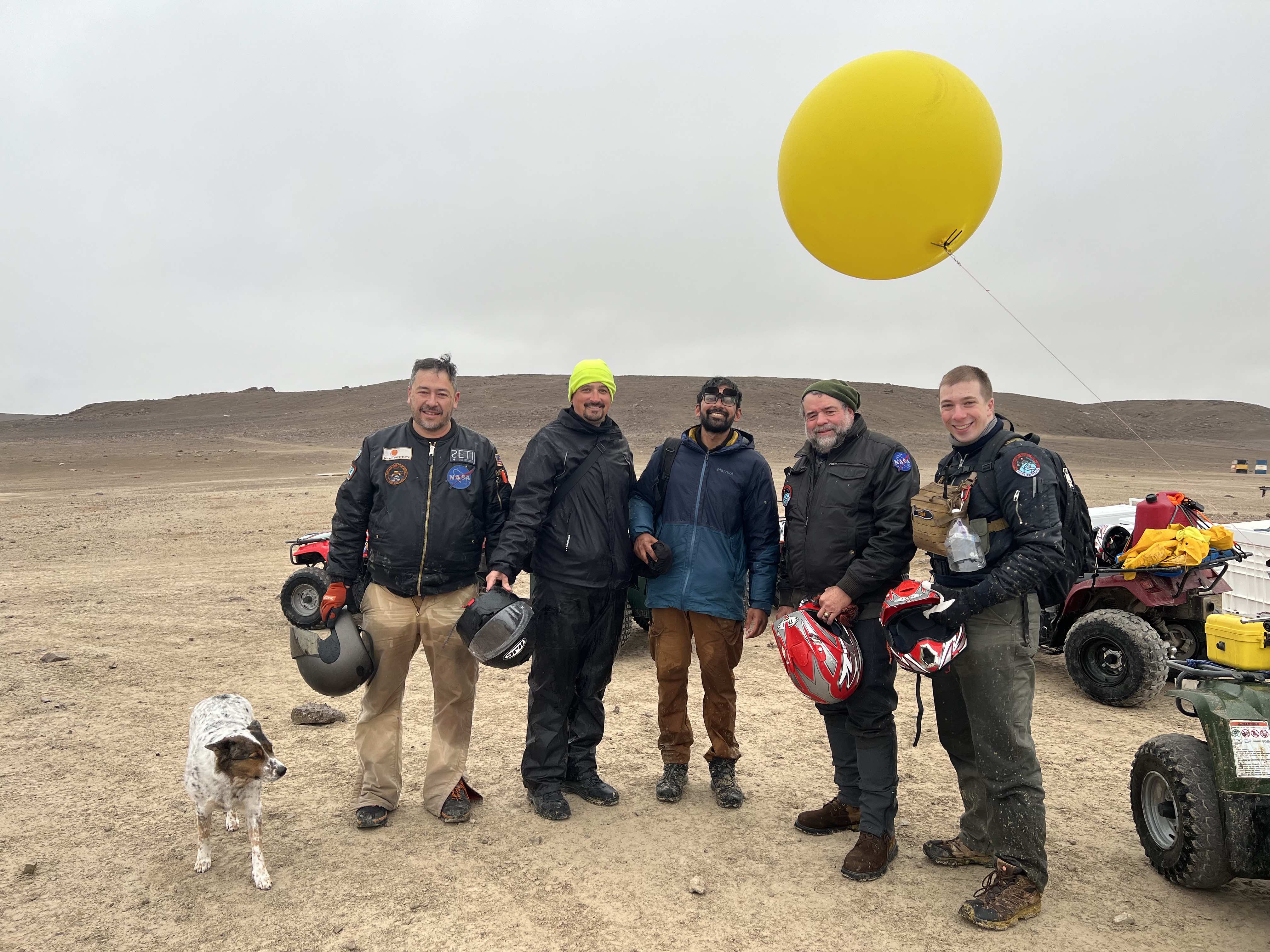 The Haughton-Mars Project team stand under a yellow weather balloon.