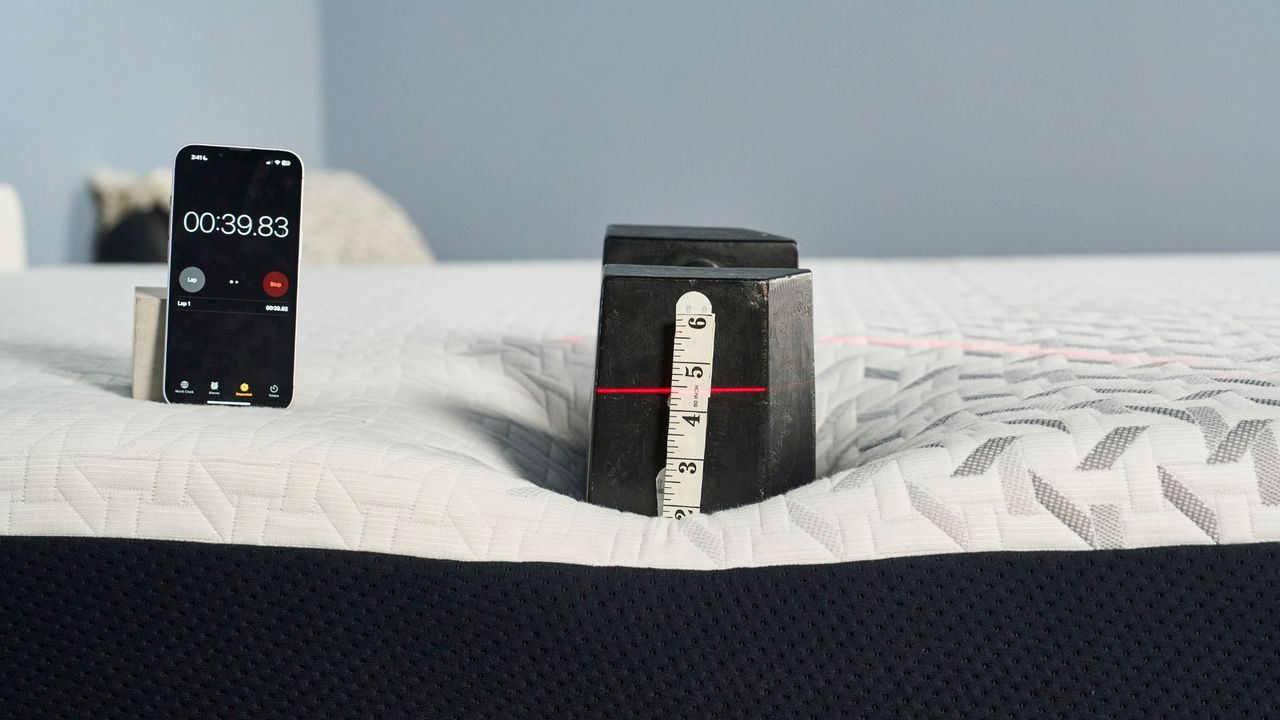 A 25kg weight is place on the side of the Nectar Premier Memory Foam Mattress to measure its sturdiness and edge support.