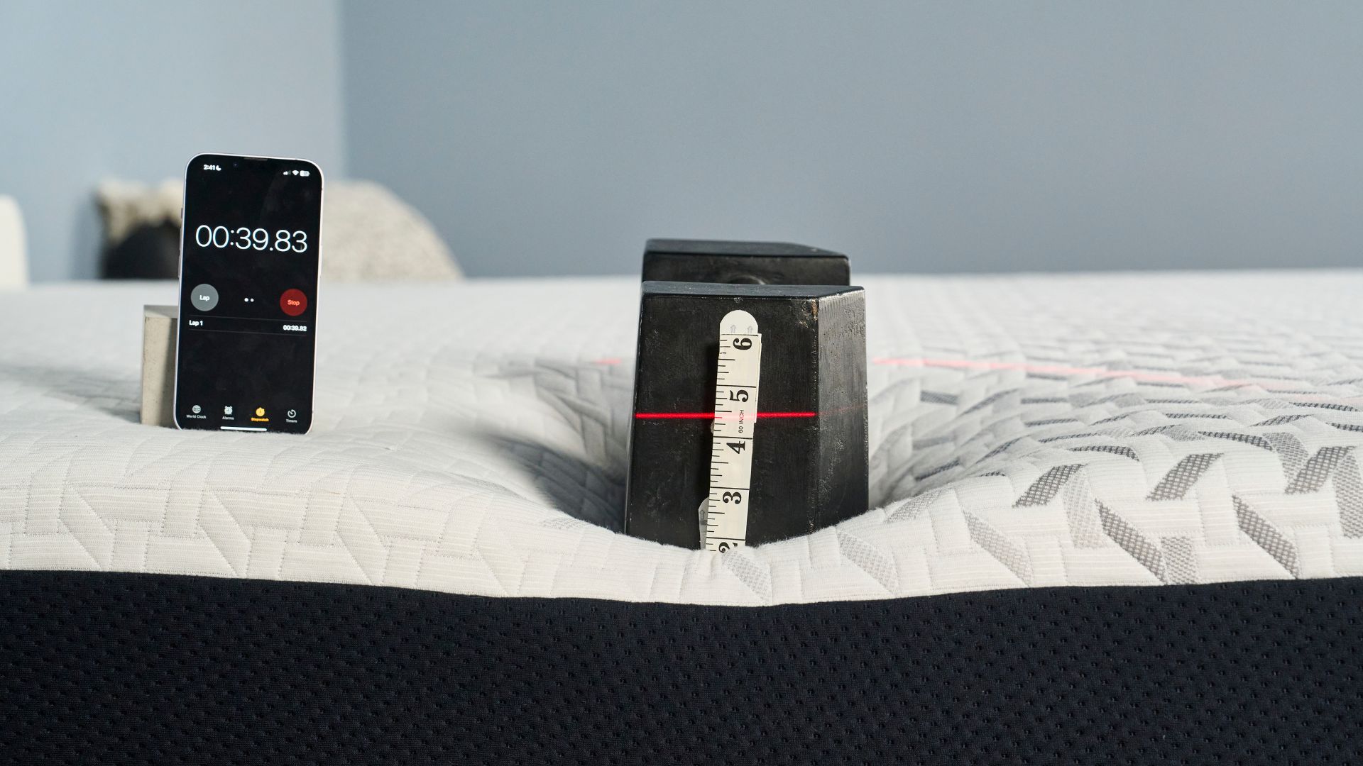 A 25kg weight is place on the side of the Nectar Premier Memory Foam Mattress to measure its sturdiness and edge support.