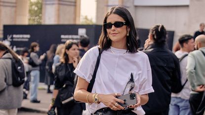 woman in a white top and black pants at Paris Fashion Week 2023