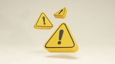 Three 3D warning triangles in yellow and black