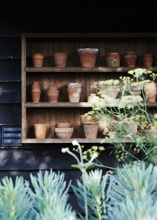 vintage terracotta pots on shelves in Bunyan's 16th century coaching inn